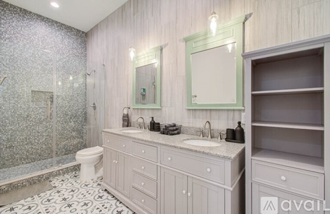 A bathroom with a white toilet, a sink, and a shower.