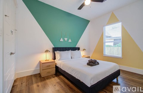 A bedroom with a bed, nightstands, and a ceiling fan.