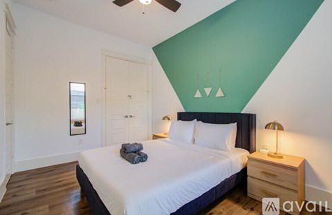 A bedroom with a bed, nightstand, and a window.