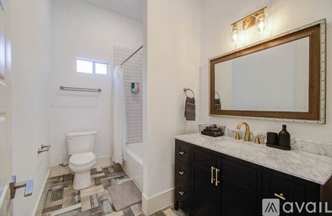 A bathroom with a toilet, sink, and a mirror.