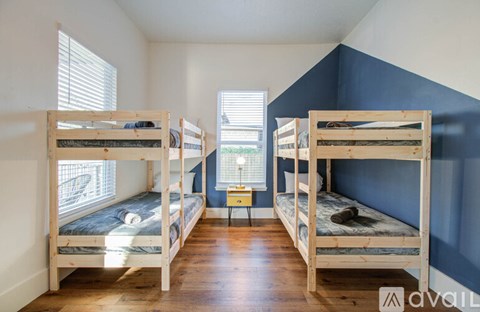 A room with bunk beds and a small table in the middle.