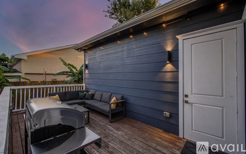A deck with a hot tub and a couch.