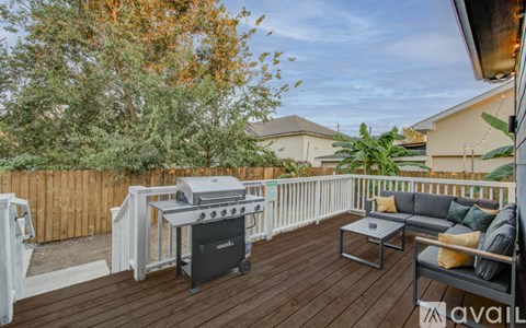 A patio with a grey couch and a black coffee table.