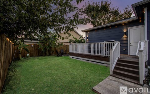 A backyard with a deck and a tree.