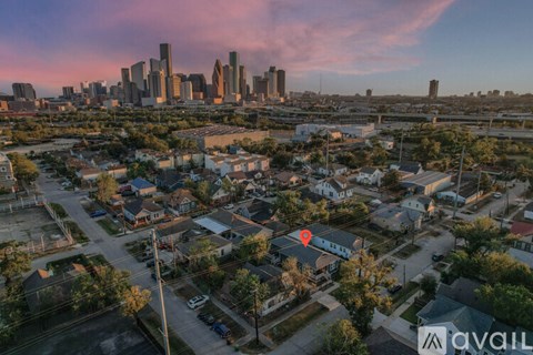 A cityscape with a red pin indicating a location in the foreground.