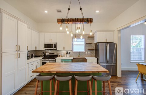 A kitchen with a wooden table and white cabinets.