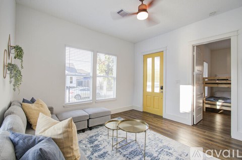 A living room with a yellow door and a white wall.