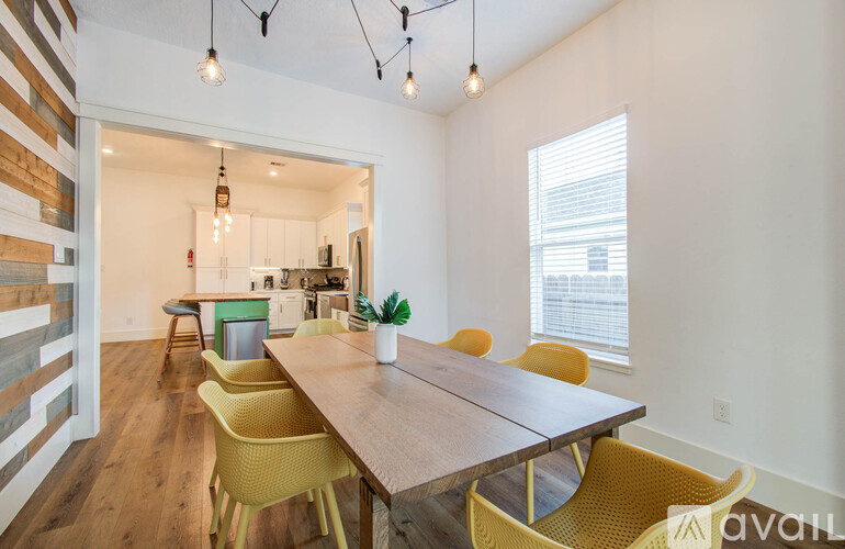A dining room with a wooden table and yellow chairs.