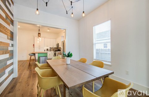 A dining room with a wooden table and yellow chairs.