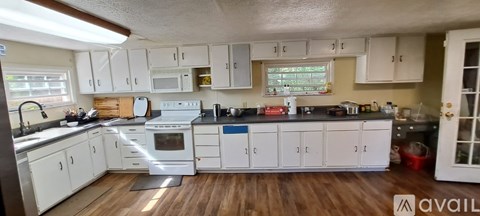 A kitchen with white cabinets and a black countertop.