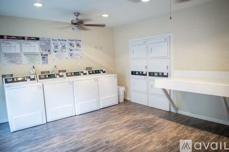 A laundry room with washers and dryers and a sign that says "Easy Washing, Single Bins".