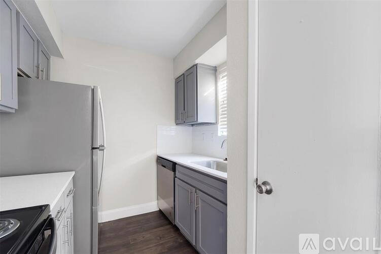 A kitchen with a refrigerator, dishwasher, and a sink.