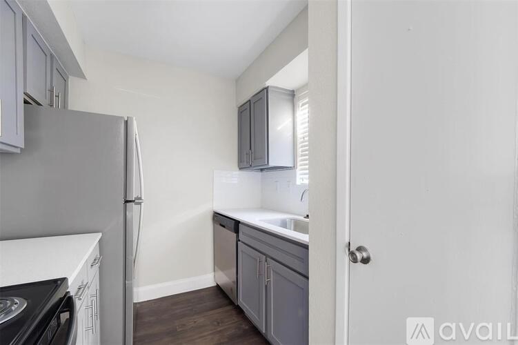 A kitchen with a refrigerator, dishwasher, and a sink.