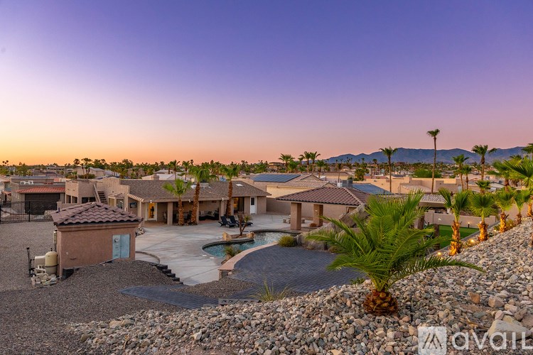 A house with a pool surrounded by palm trees.