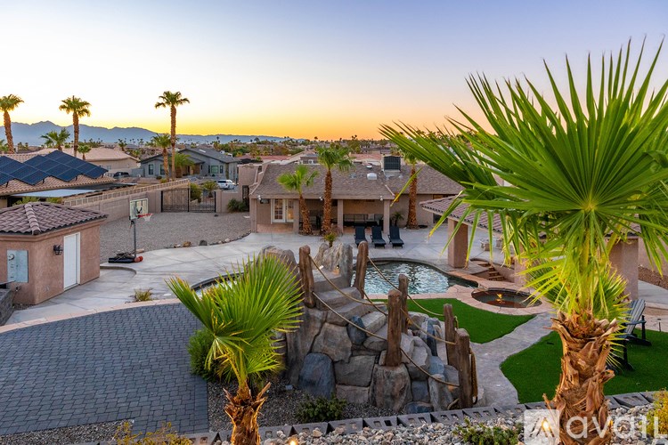 A beautifully landscaped backyard with a pool and palm trees.