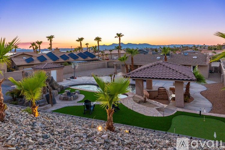 A sunset view of a residential area with palm trees and houses.