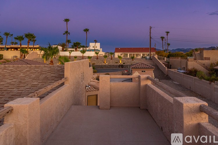 A sunset view of a residential area with houses and palm trees.