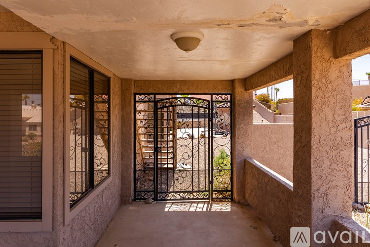 A balcony with a metal gate and a view of a street.