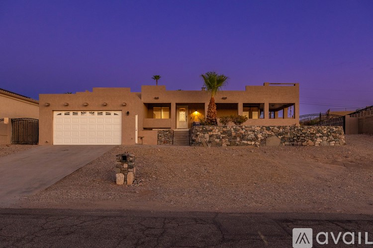 A house with a garage and a palm tree in front.