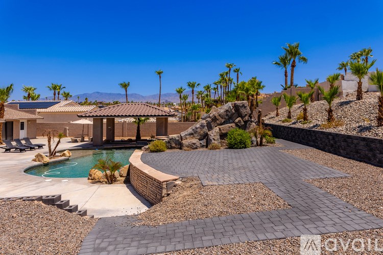 A backyard with a pool and patio area.