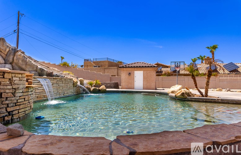 A pool with a waterfall surrounded by rocks.