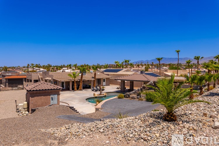 A desert-style home with a pool and palm trees.