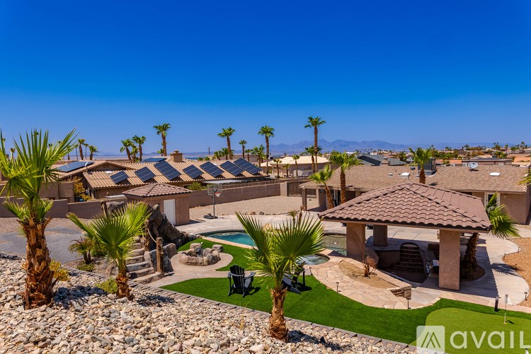 A sunny day at a resort with palm trees and a pool.