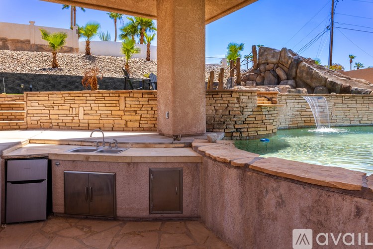 A pool with a waterfall and a stone wall.