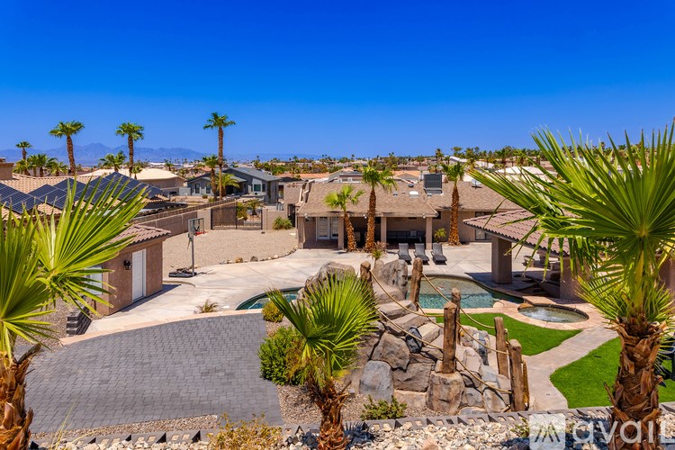 A luxurious villa with a swimming pool surrounded by palm trees.