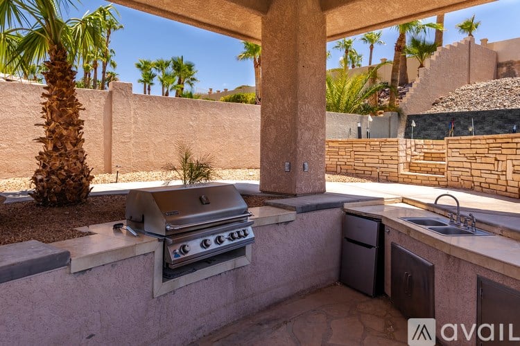 A patio with a grill and a sink.