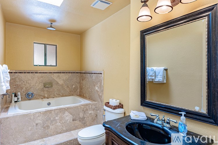 A bathroom with a black sink and a large mirror.