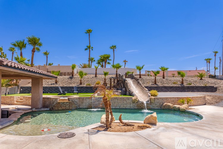 A pool with a waterfall and palm trees in the background.