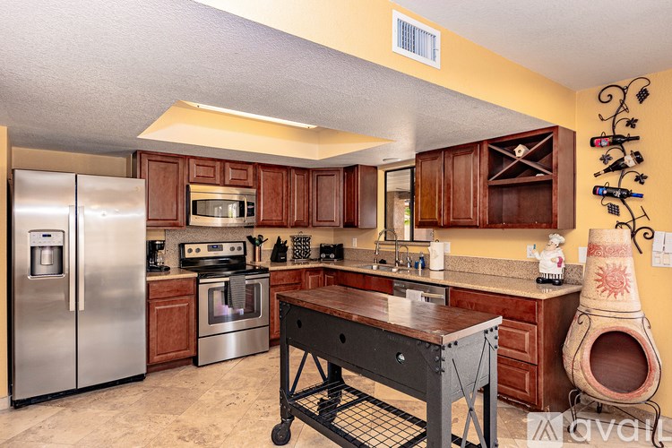 A kitchen with a black table and stainless steel appliances.