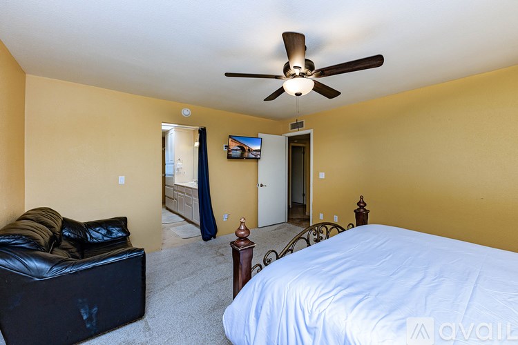 A bedroom with a bed, couch, and television.