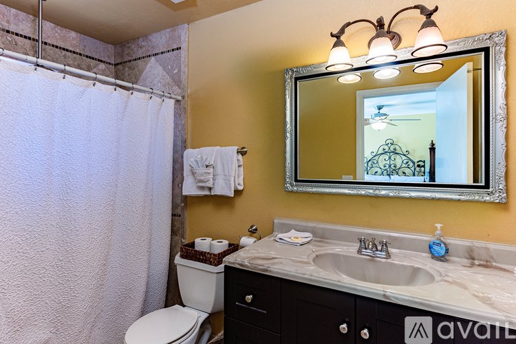 A bathroom with a toilet, sink, and shower.