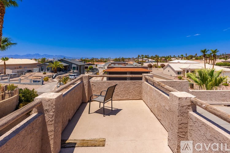 A balcony with a chair and a view of a residential area.