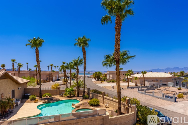 A pool surrounded by palm trees and a mountain in the distance.