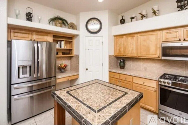 A kitchen with a granite countertop and stainless steel appliances.