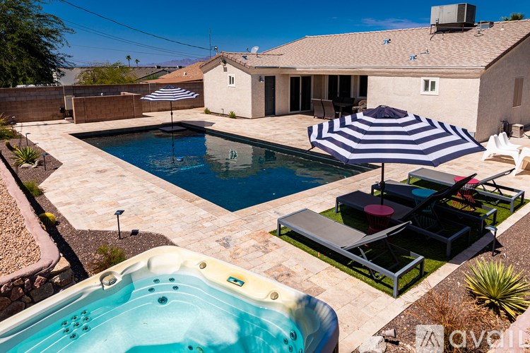 A backyard with a hot tub and a pool.