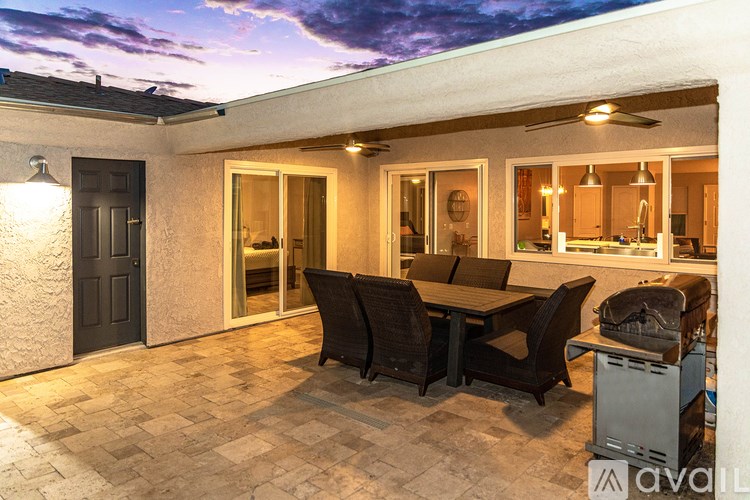 A patio with a table and chairs is set up outside a house.