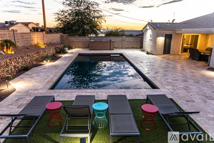 A backyard with a pool and a table and chairs set up.