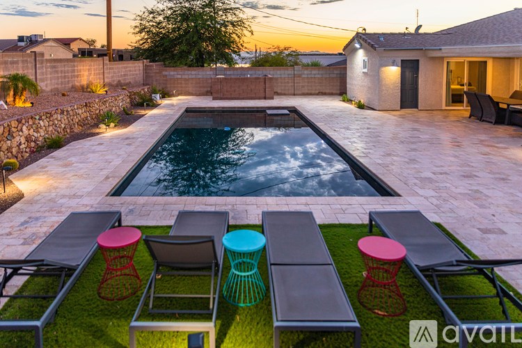 A backyard with a pool and a patio furniture set.
