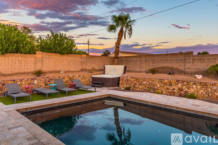A pool surrounded by a stone wall with a palm tree in the background.