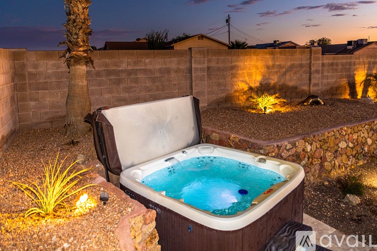 A hot tub in a backyard at night.