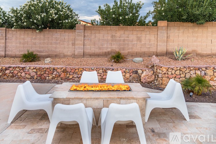 A patio with a table and chairs and a fire pit.
