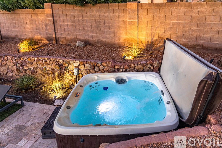 A hot tub is sitting on a patio with a wall behind it.