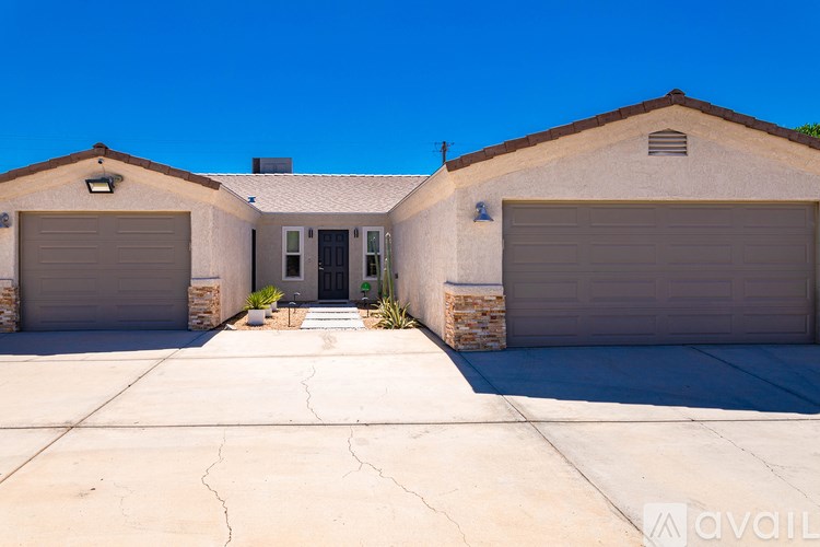 A house with two garages and a driveway in front.