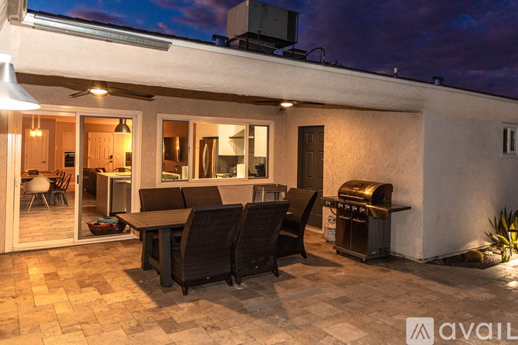 A patio with a table and chairs is set up outside a house.