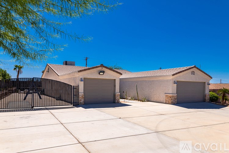 A house with a black gate and two garages.