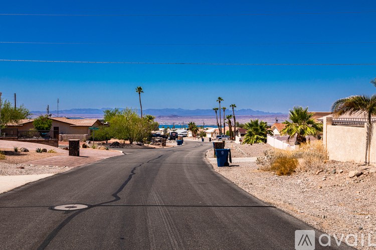 A street in a desert with a mountain in the distance.